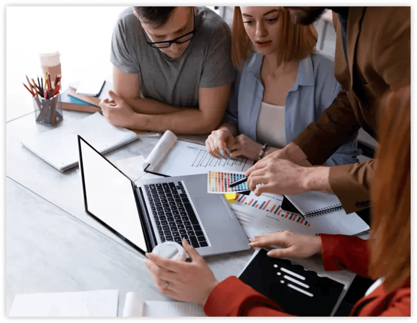 group of people looking at laptop screen