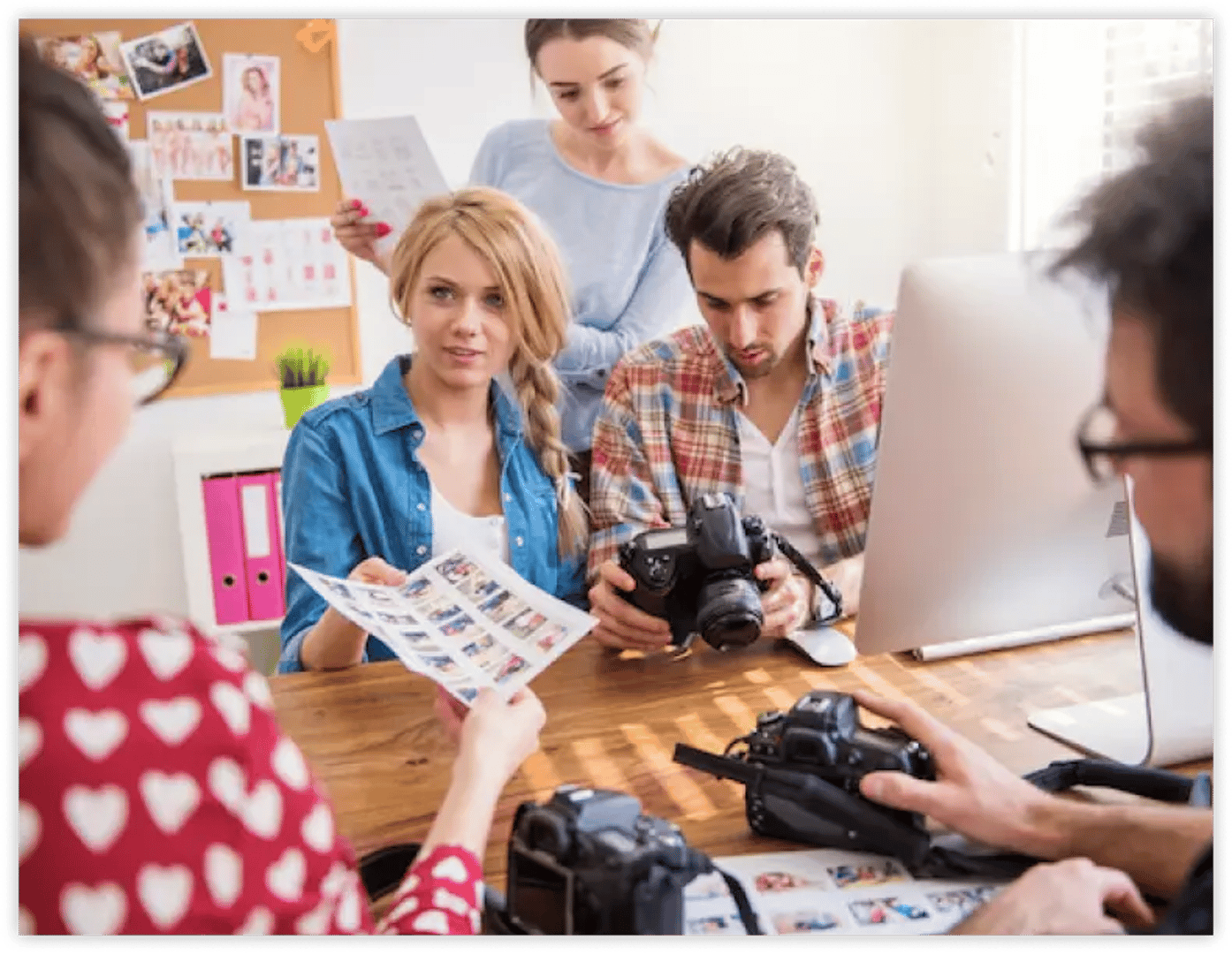 a group of photographer showing the result of their shoot to their teacher